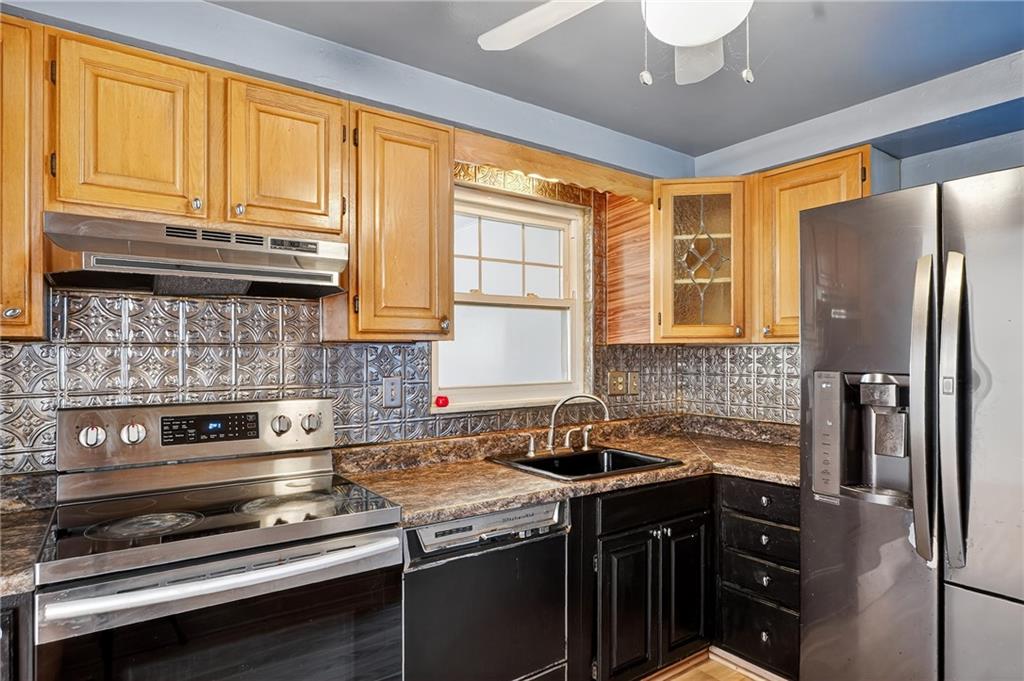 1209 Varner Road Pittsburgh, PA 15227 - Photo 13 of 40 a kitchen with stainless steel appliances granite countertop a sink stove and refrigerator