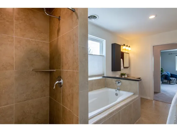 a bathroom with a tub a sink and mirror