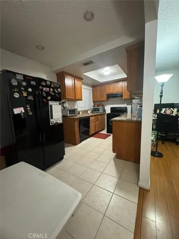 a kitchen with stainless steel appliances kitchen island granite countertop a refrigerator and a stove