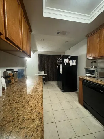 a kitchen with granite countertop a refrigerator and a sink