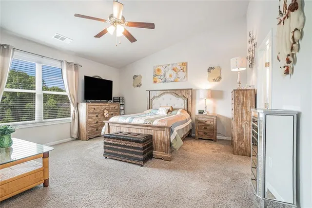 a bedroom with a bed dresser and a flat screen tv