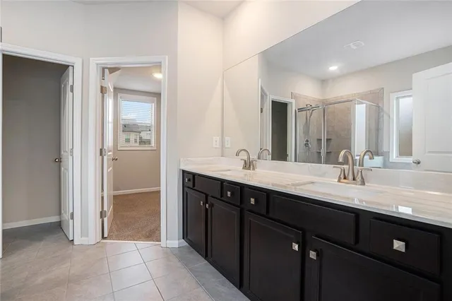 a bathroom with a granite countertop sink double and mirror