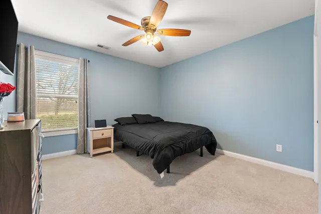 a bedroom with a bed and a ceiling fan