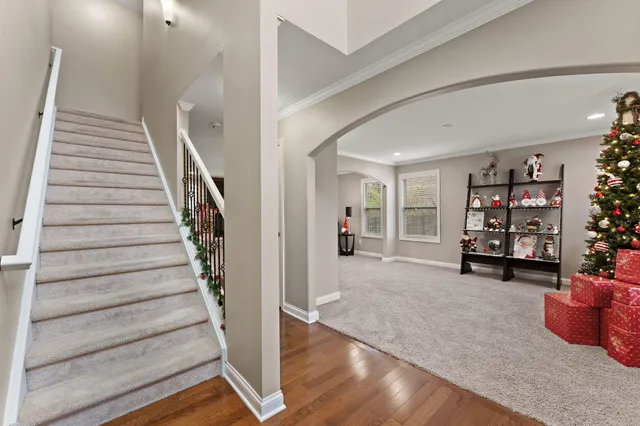 a view of an empty room with bookshelf and stairs