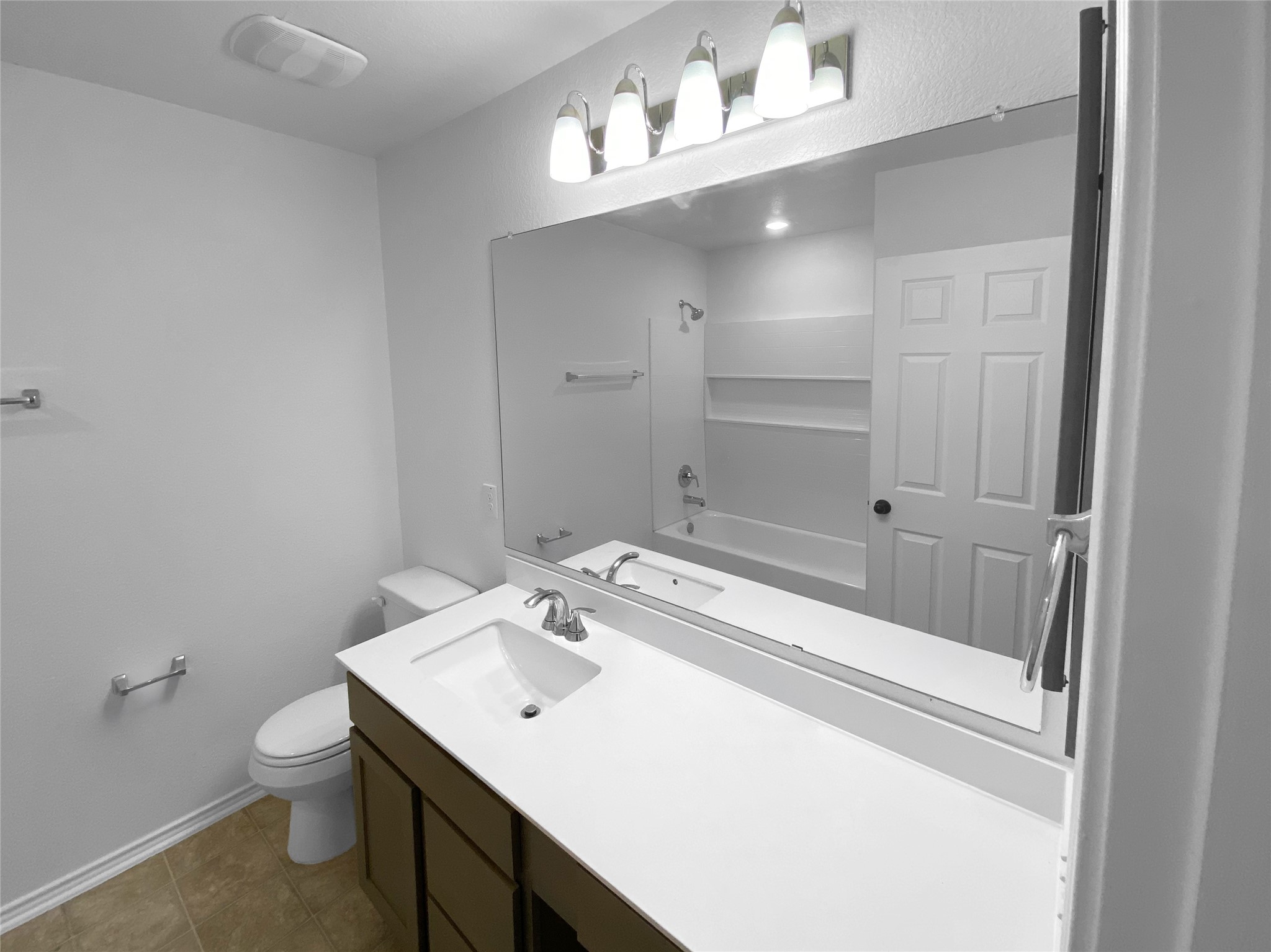 932 Yellow Ribbon Trail Jarrell, TX 76537 - Photo 15 of 26 Bathroom with vanity, washtub / shower combination, and dark tile patterned floors
