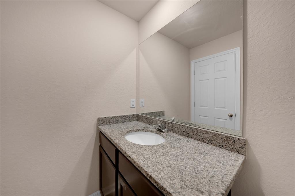11057 Pendleton Avenue Englewood, FL 34224 - Photo 14 of 37 a bathroom with a granite countertop sink and a mirror