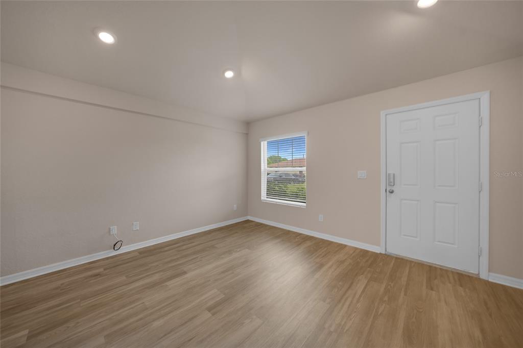 11057 Pendleton Avenue Englewood, FL 34224 - Photo 10 of 37 an empty room with wooden floor and windows