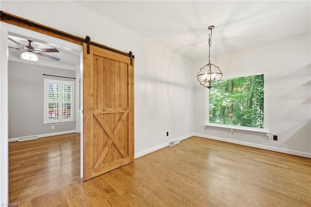8861 Boylston Road Colfax, NC 27235 - Photo 15 of 50 Dining Room featuring a custom sliding barn door opening to the flex room, with easy access to the kitchen and views toward the heart of the home.