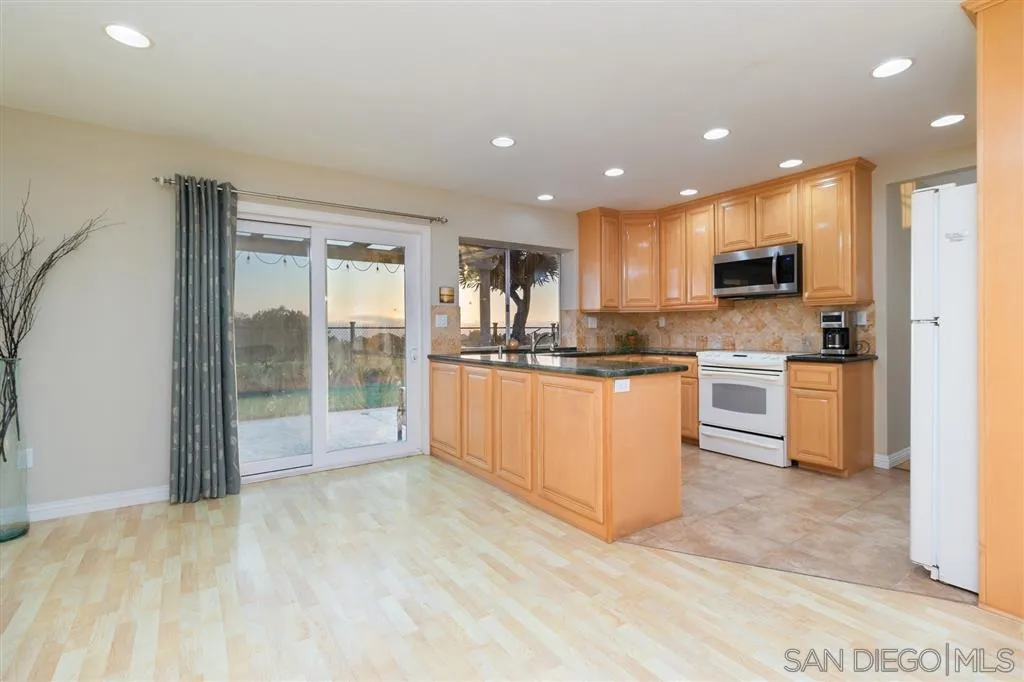 13524 Ridley Road San Diego, CA 92129 - Photo 14 of 23 a kitchen with stainless steel appliances granite countertop a stove a sink and a refrigerator