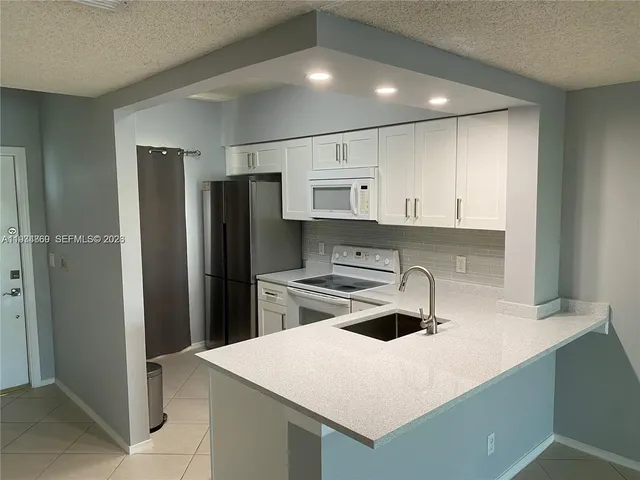a kitchen with refrigerator and cabinets