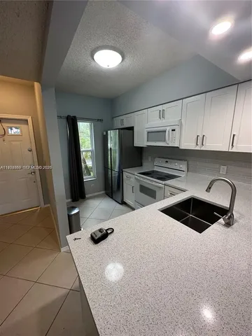 a kitchen with a sink a stove and refrigerator