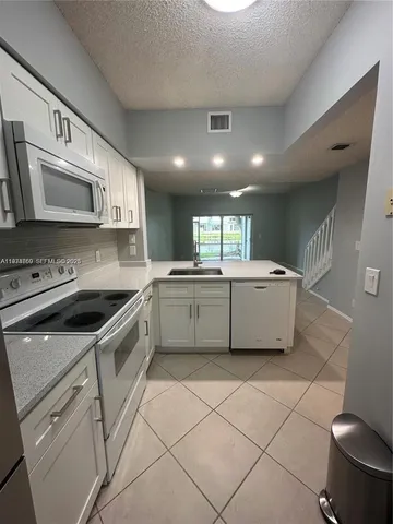 a kitchen with stainless steel appliances a sink stove and cabinets