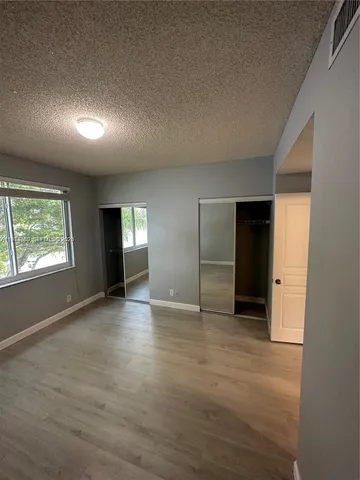 an empty room with window and wooden floor