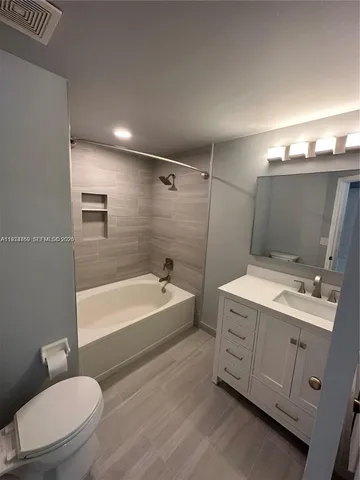 a bathroom with a double vanity sink toilet mirror and bathtub