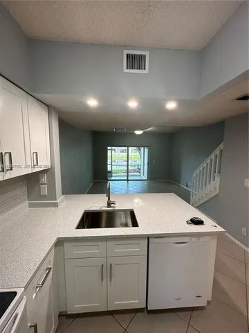 a kitchen with kitchen island sink and window