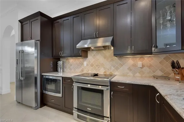 a kitchen with granite countertop stainless steel appliances and wooden cabinets