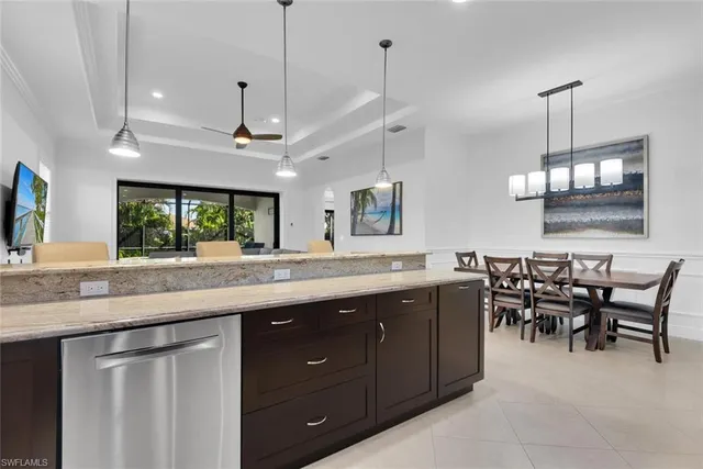 a kitchen with lots of wooden furniture appliances and a chandelier