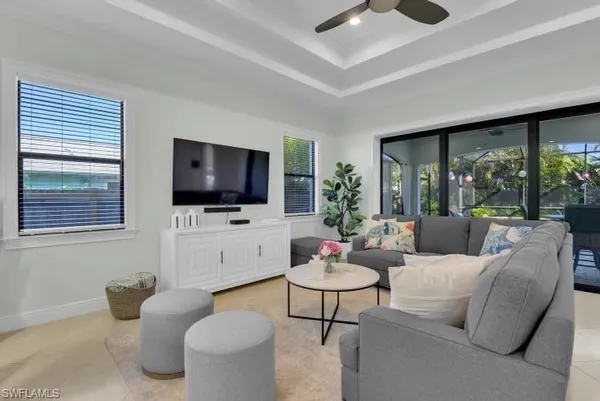 a living room with furniture a flat screen tv and a floor to ceiling window