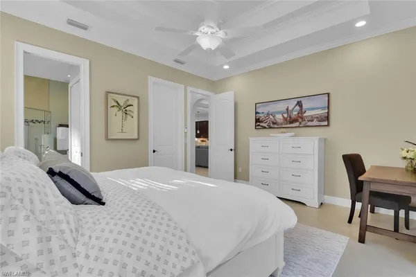 a bedroom with a large bed and a chandelier