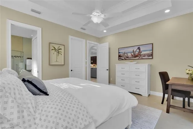 a bedroom with a large bed and a chandelier