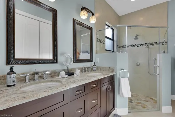 a bathroom with double vanity sinks and a mirror