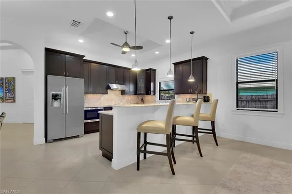 a kitchen with refrigerator and chairs