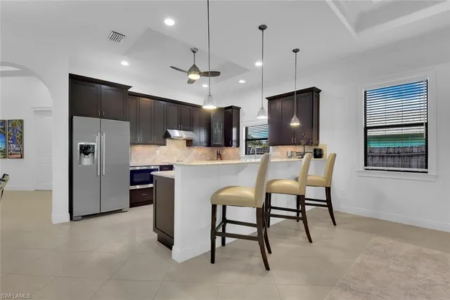 a kitchen with refrigerator and chairs