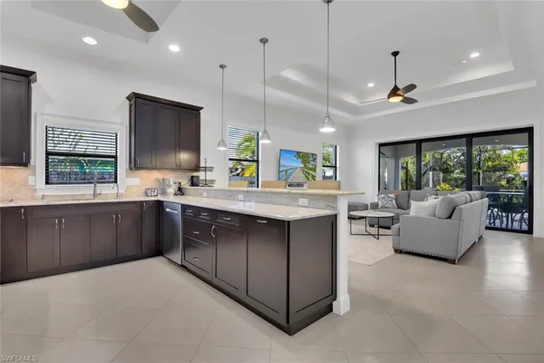 a kitchen with kitchen island granite countertop a sink stove and wooden floor