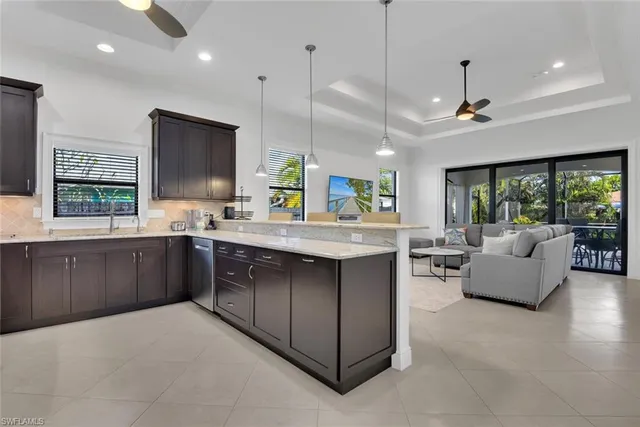 a kitchen with kitchen island granite countertop a sink stove and wooden floor