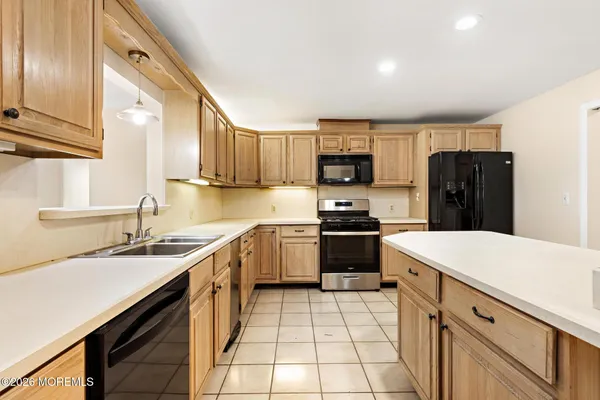 a kitchen with a sink a stove top oven and refrigerator
