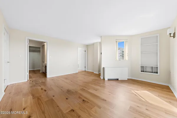 a view of empty room with wooden floor