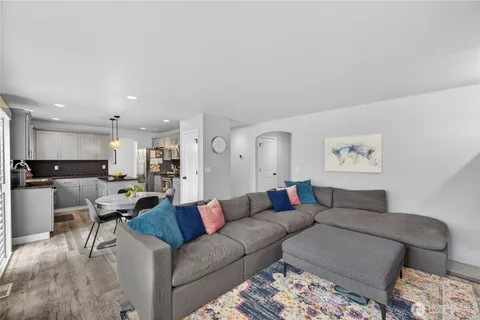 a living room with furniture and a dining table with kitchen view