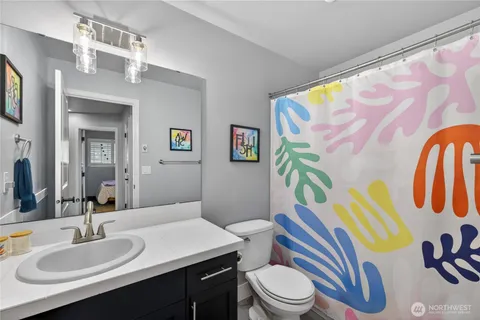 a bathroom with a sink a toilet and shower curtain