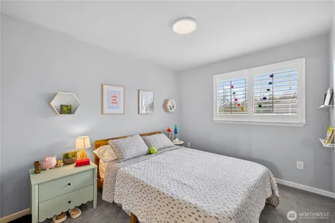 a bedroom with a bed and painting on the wall