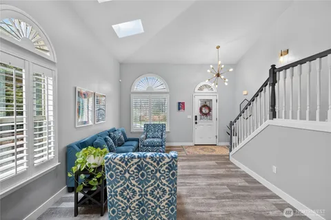 a living room with furniture chandelier and a window