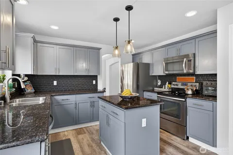 a kitchen with stainless steel appliances granite countertop a sink stove and refrigerator