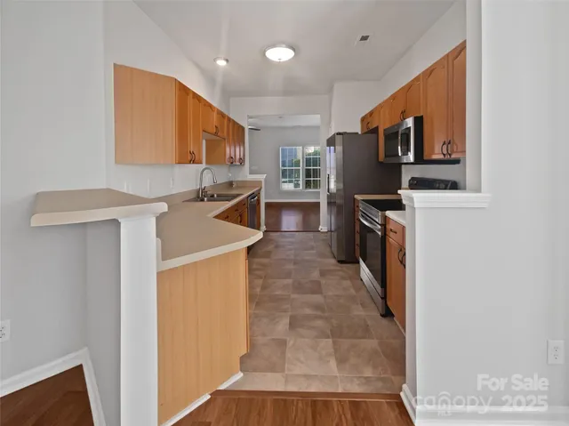 a kitchen with stainless steel appliances granite countertop a stove top oven a sink a counter top space and cabinets