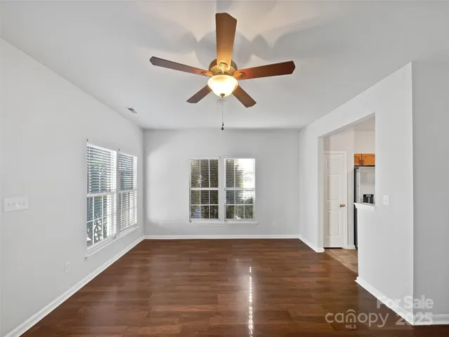 a view of an empty room with window and wooden floor