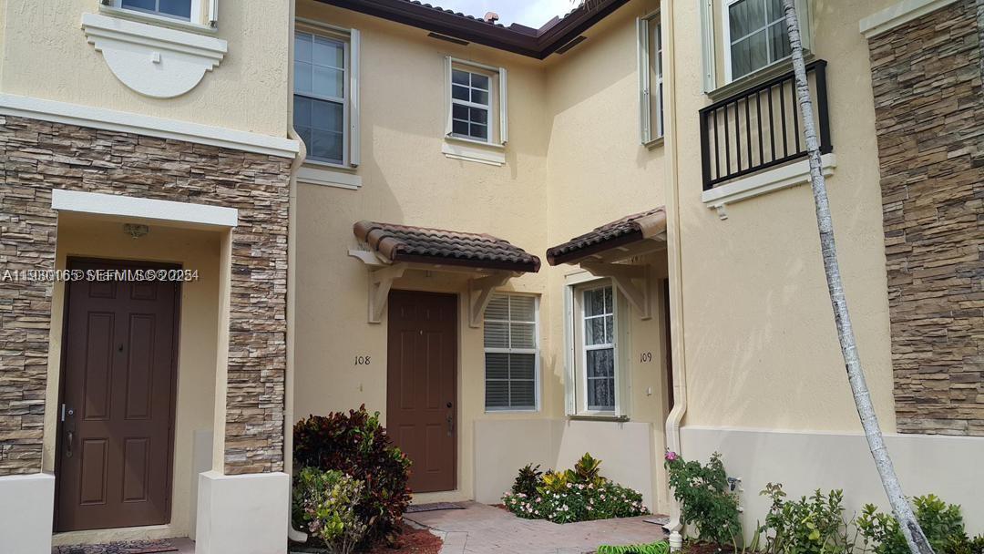 1398 Northeast 33rd Avenue, Unit 10825 Homestead, FL 33033 - Photo 5 of 8 a front view of a house with a garden