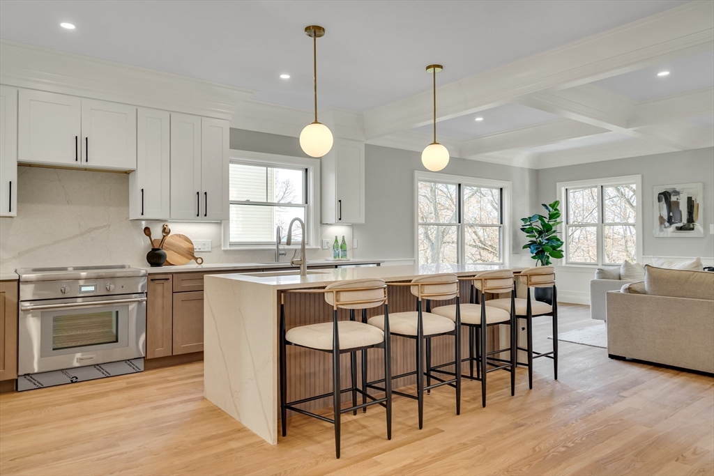 24 Deering Avenue Lexington, MA 02421 - Photo 9 of 42 a kitchen with stainless steel appliances granite countertop wooden floor dining table and chairs