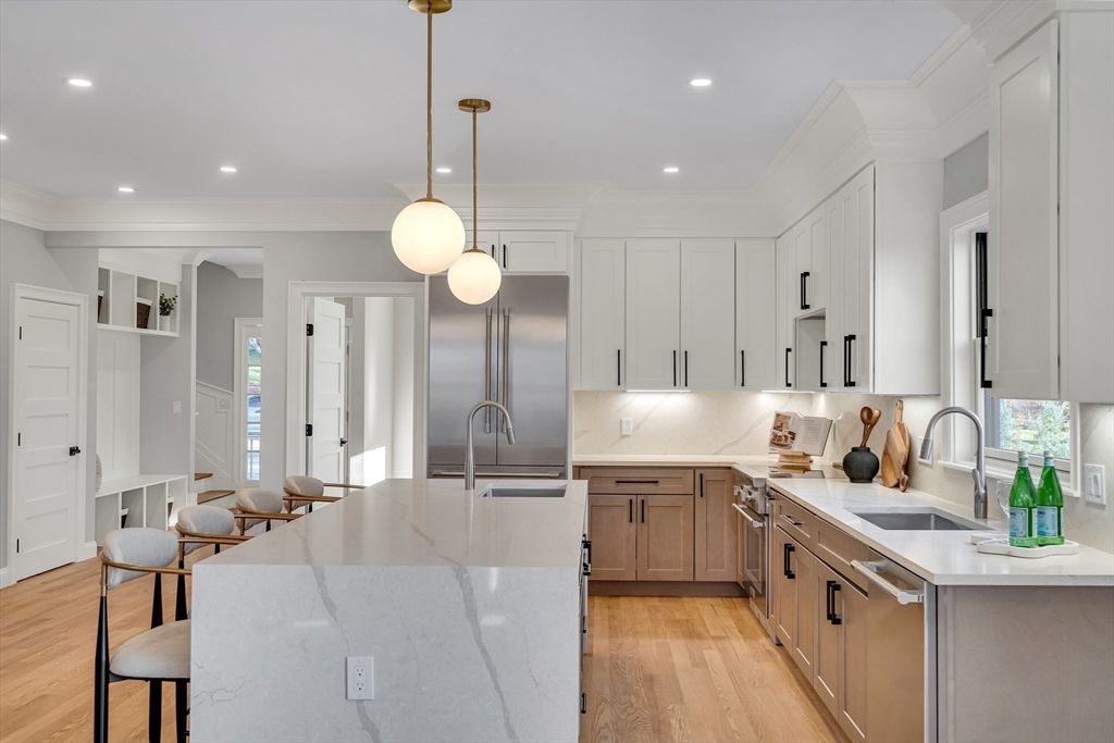 24 Deering Avenue Lexington, MA 02421 - Photo 10 of 42 a large kitchen with stainless steel appliances kitchen island a large counter top a sink a stove and a refrigerator
