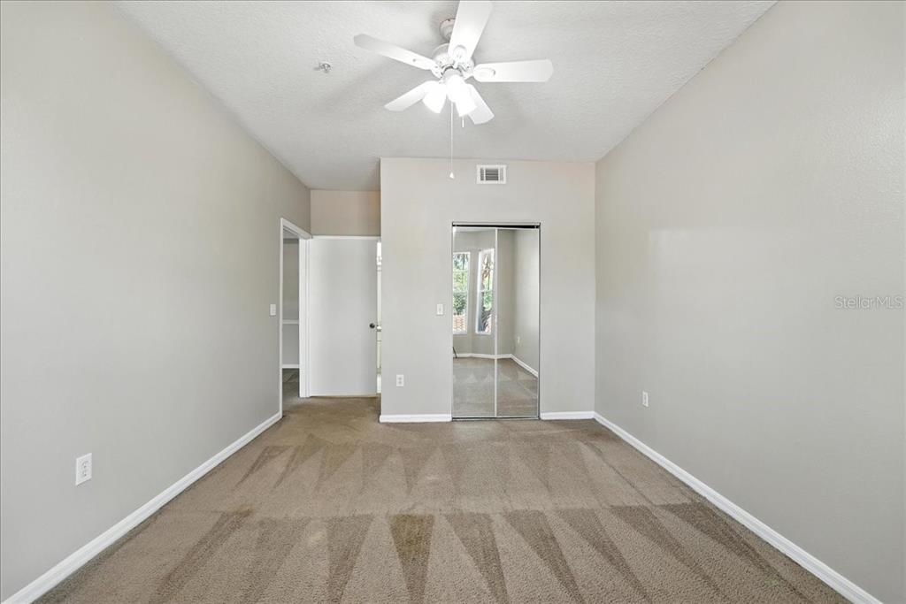 5572 Metrowest Boulevard, Unit 202 Orlando, FL 32811 - Photo 11 of 13 an empty room with fan and entrance