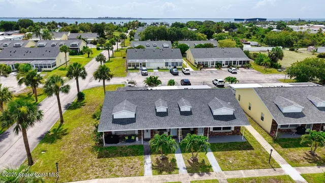 an aerial view of residential houses with outdoor space and parking