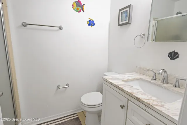 a bathroom with a granite countertop sink toilet and a mirror