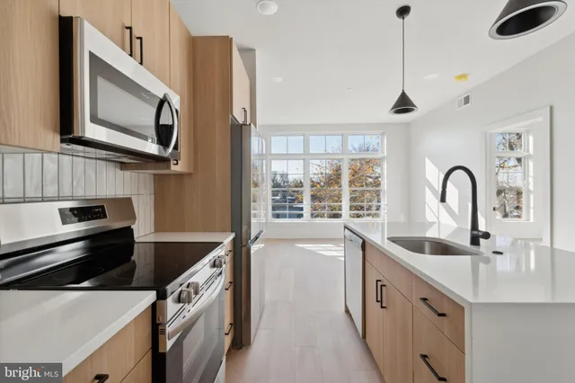 a kitchen with stainless steel appliances a sink a stove and a microwave