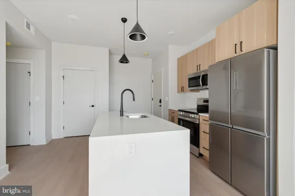 a kitchen with stainless steel appliances a refrigerator sink and microwave