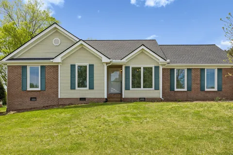 a front view of a house with a yard and trees
