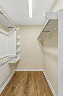 an empty room with wooden floor & closet area