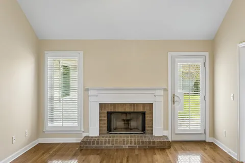 an empty room with wooden floor and a ceiling fan