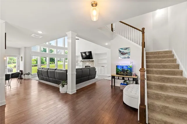 a view of a living room and kitchen with furniture wooden floor and windows